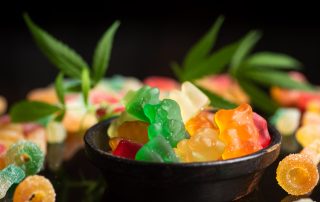 Llaminadures de gelatina de colors en un bol, amb fulles de cànnabis de decoració